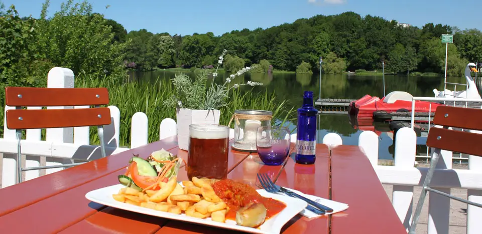 ... Tisch mit Essen und Getränken am Seeufer