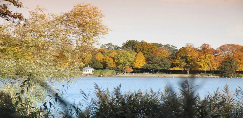 ... Herbstlich gefärbter See mit Pavillon im Hintergrund